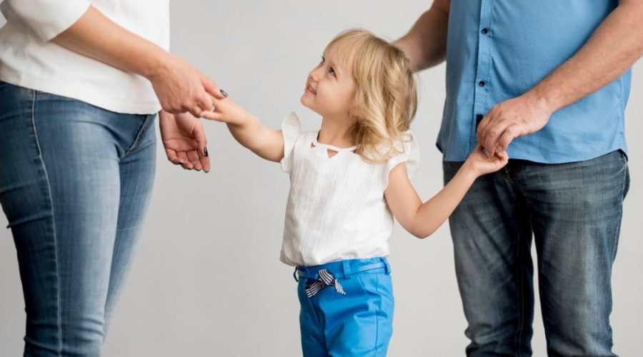 Niña con sus dos progenitores durante un proceso de custodia de hijos