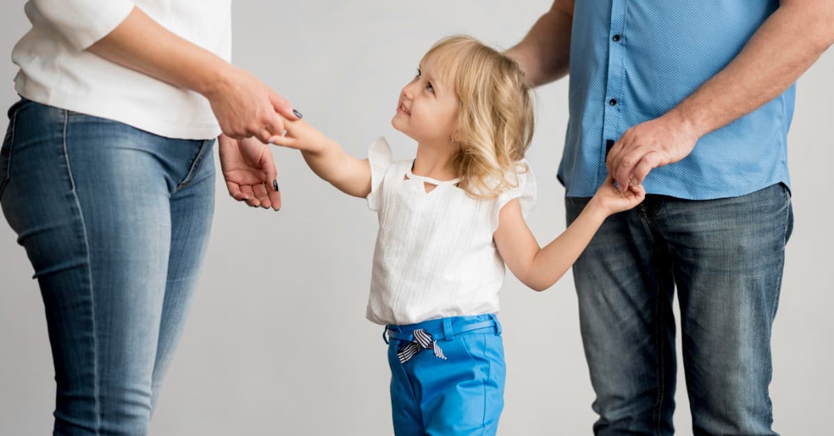 Niña con sus dos progenitores durante un proceso de custodia de hijos